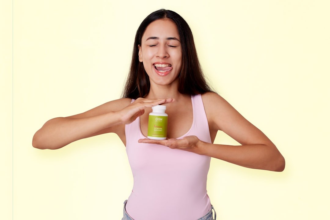 Woman model holding Osh Wellness Hormone Support supplement jar in her hand with a goofy expression. from oshwellness.com